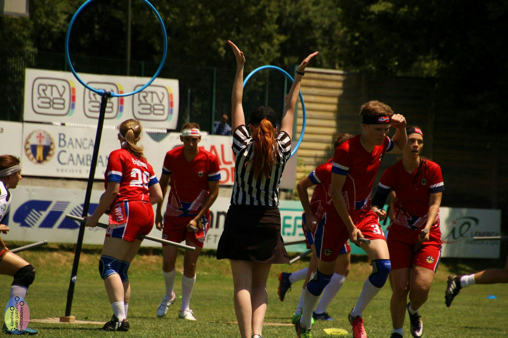 Referee signals a successful goal during a Quidditch match